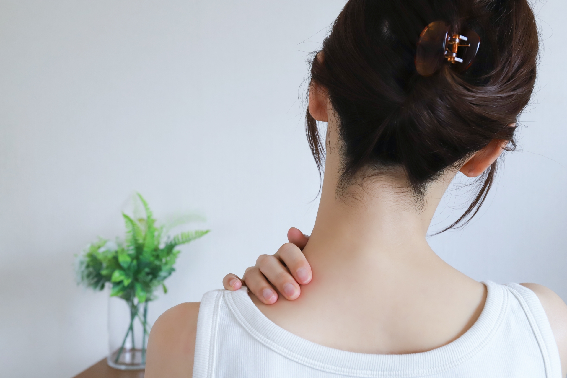 肩に手を当てる女性