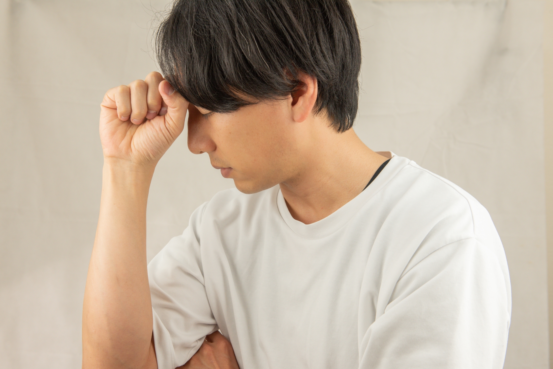 額に手を当てる男性