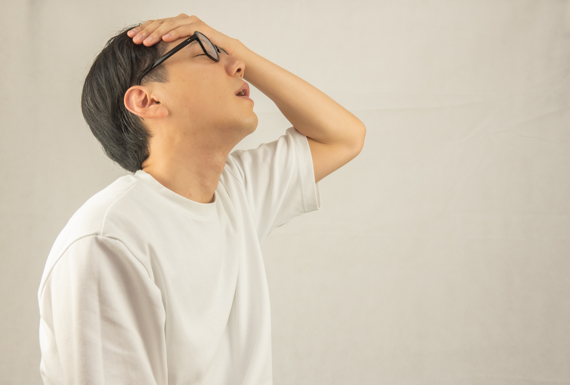 額に手を当てる男性